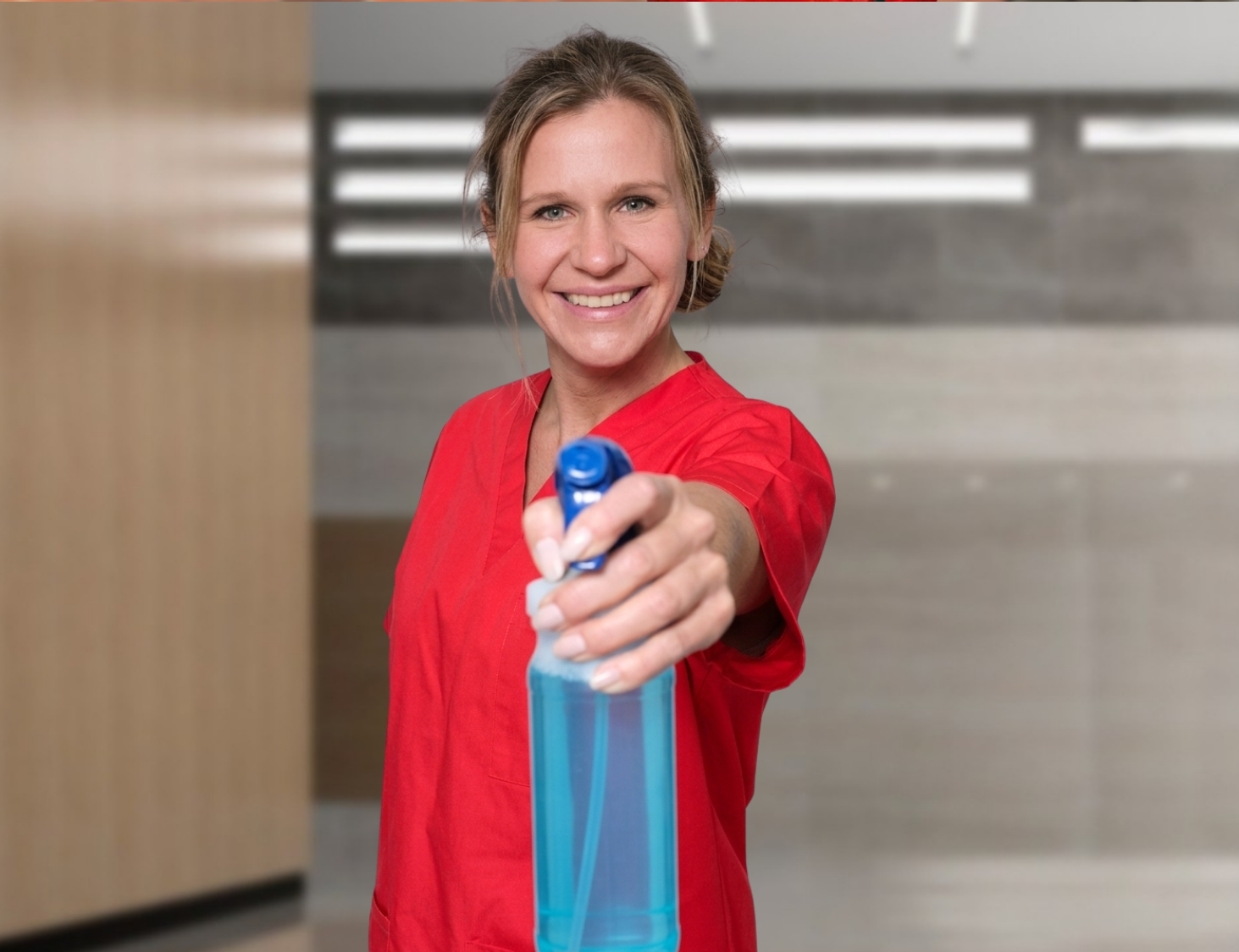 Reinigungskraft von CityCleaner mit Sprühflasche in der Hand bei der Grundreinigung in Gelsenkirchen