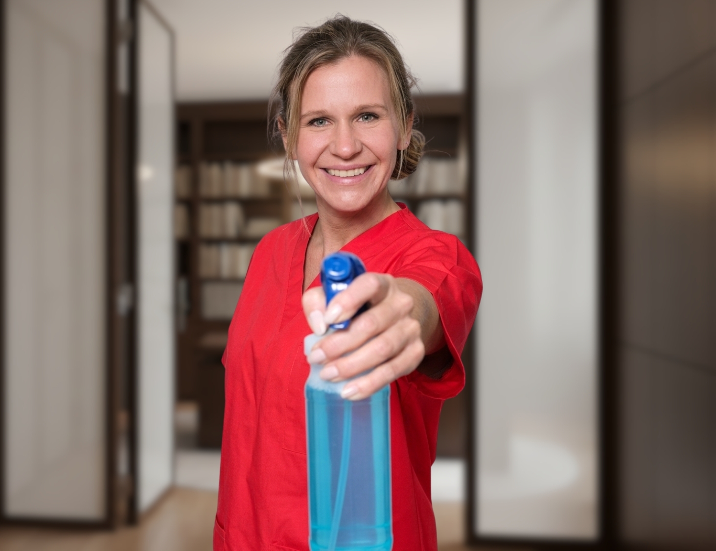 Reinigungskraft von CityCleaner mit Sprühflasche in der Hand bei der Kanzleireinigung in Gelsenkirchen