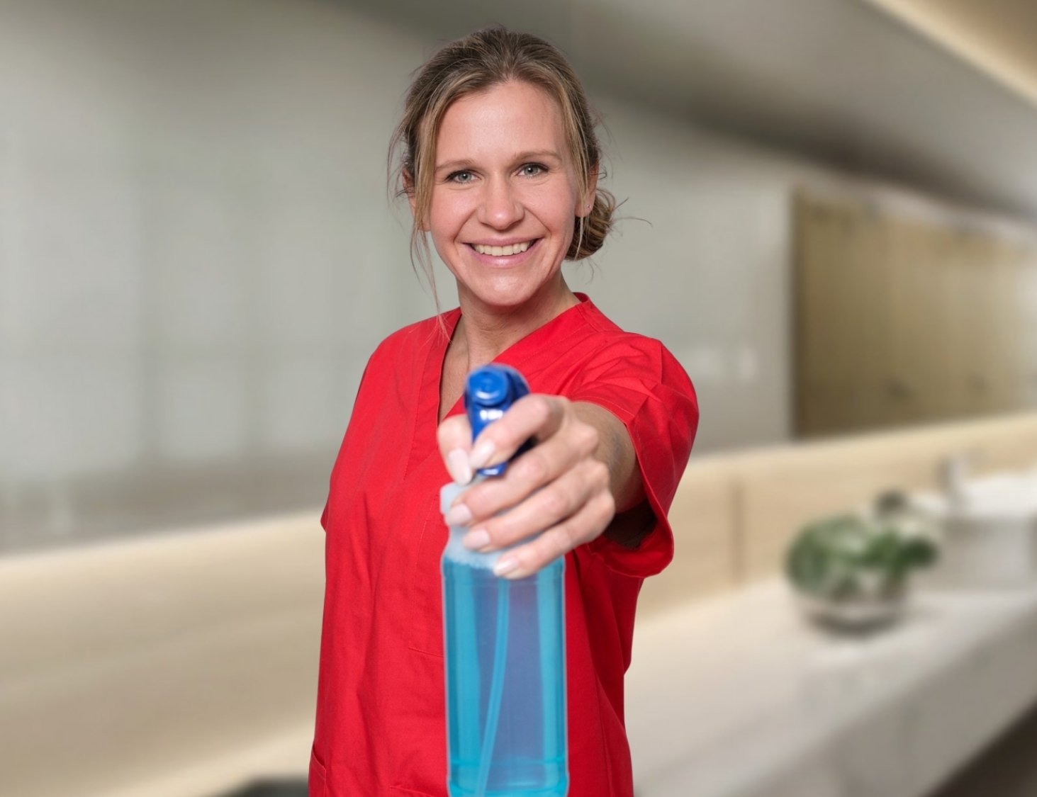 Reinigungskraft von CityCleaner mit Sprühflasche in der Hand bei der Unterhaltsreinigung in Gelsenkirchen